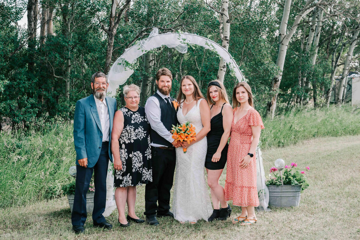 Bride and groom standing with grooms family.