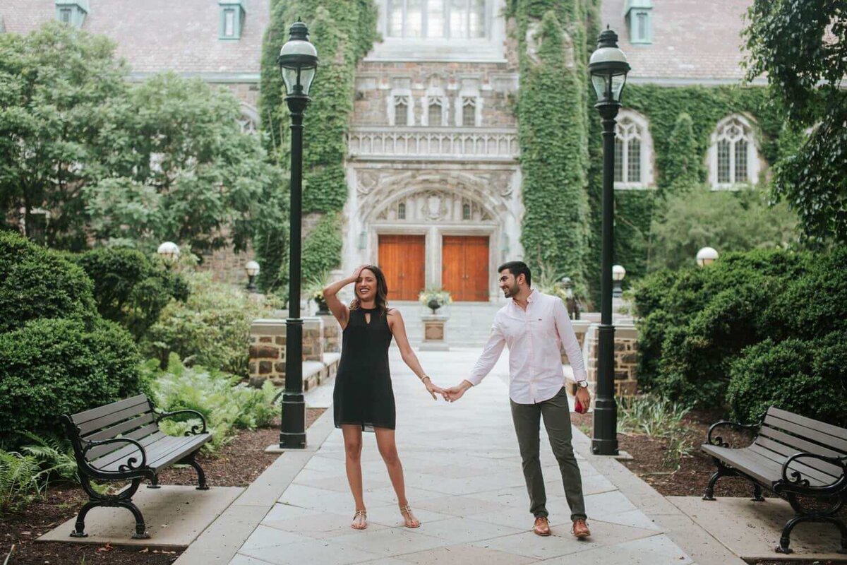 Soon to be married couple holding hands in the Lehigh Valley. The background is filled with greenery and a beautiful concrete path.