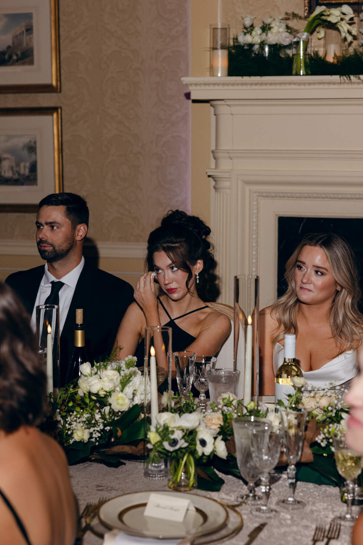 A wedding photo of the bride and her sister sitting together during the wedding reception