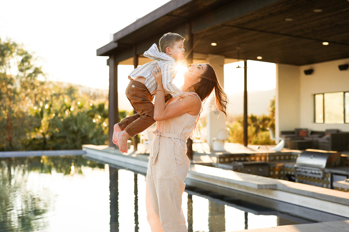 Mom holding son with sunset in background. Photo by Portland Oregon family photographer.