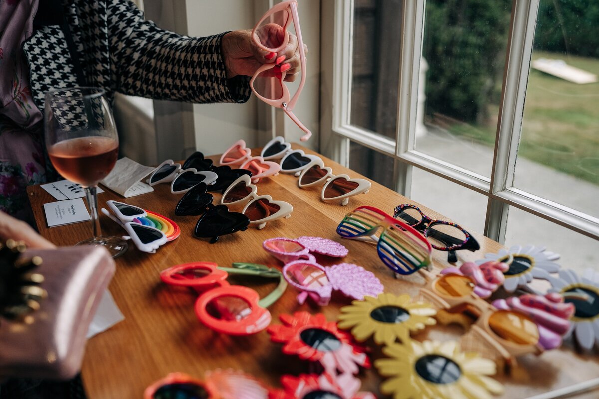 a range of novelty sunglasses props laid out on a table beside a photo booth at pemberton