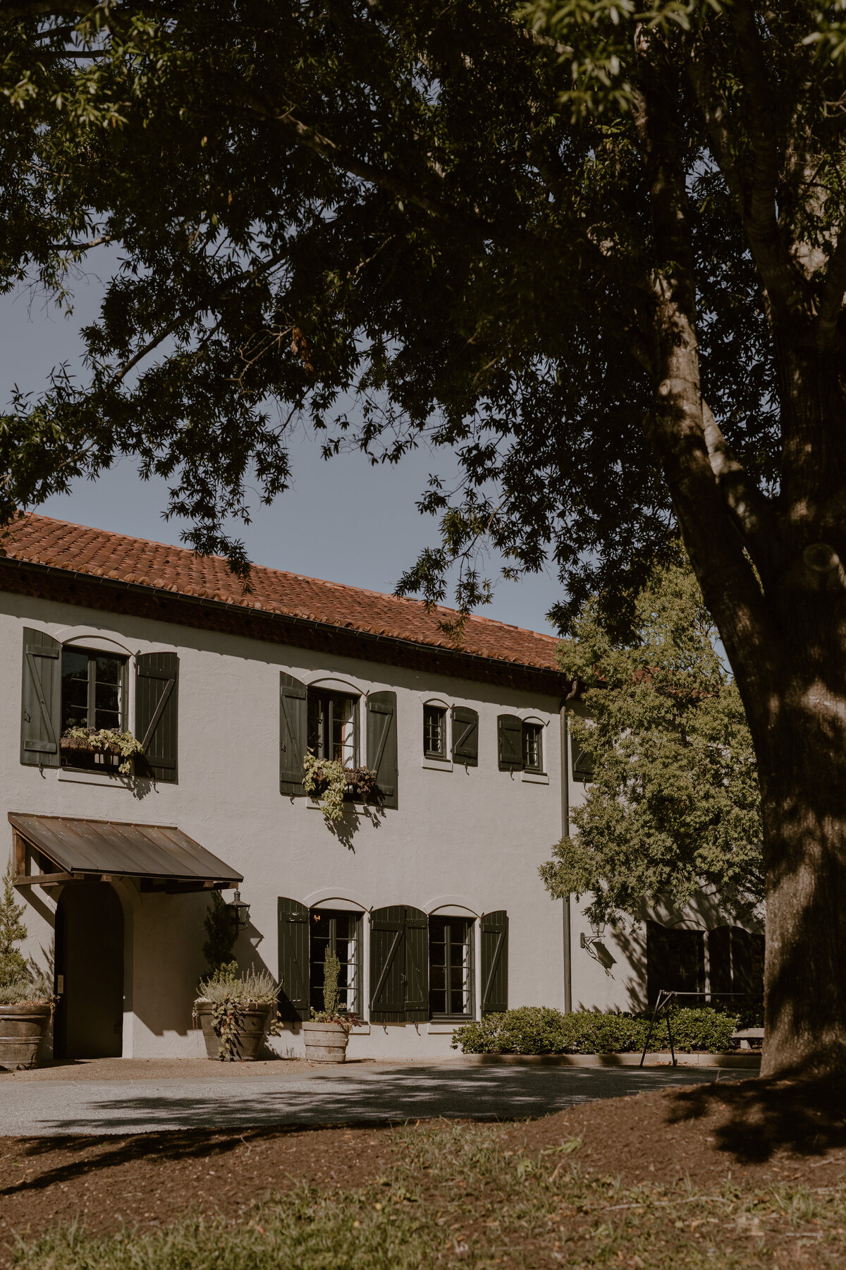 European-style stone building of Hotel Domestique surrounded by lush landscaping.
