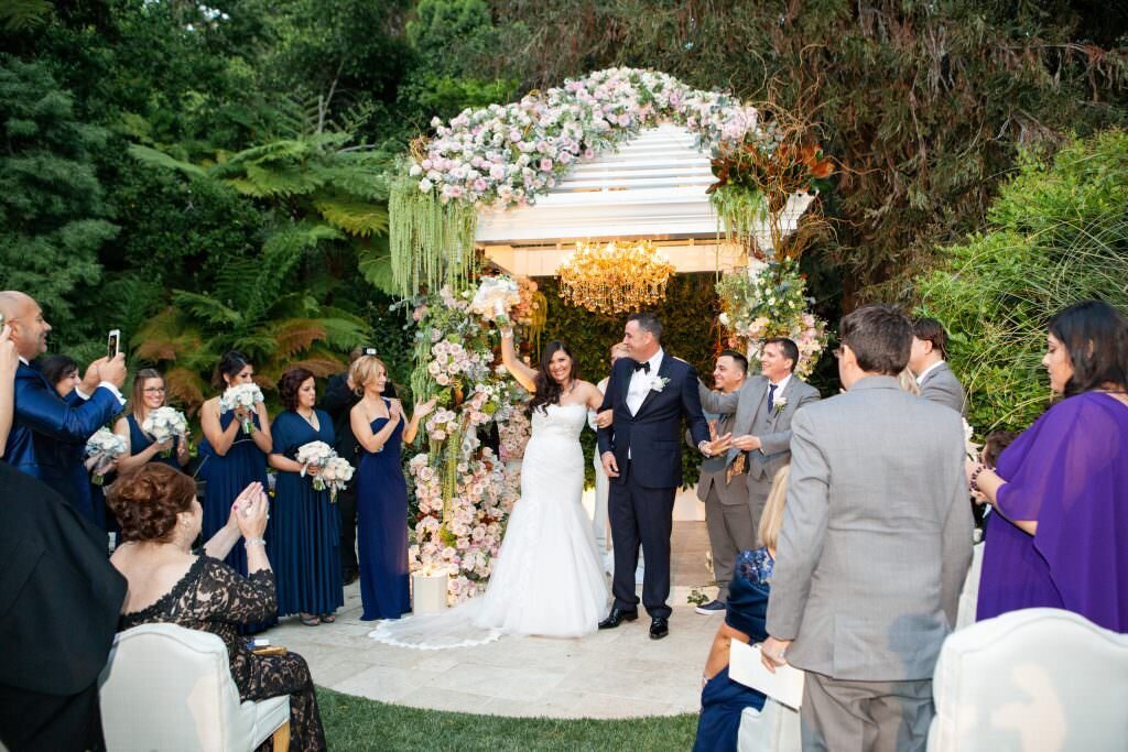 A bride and groom walking back up the aisle celebrating