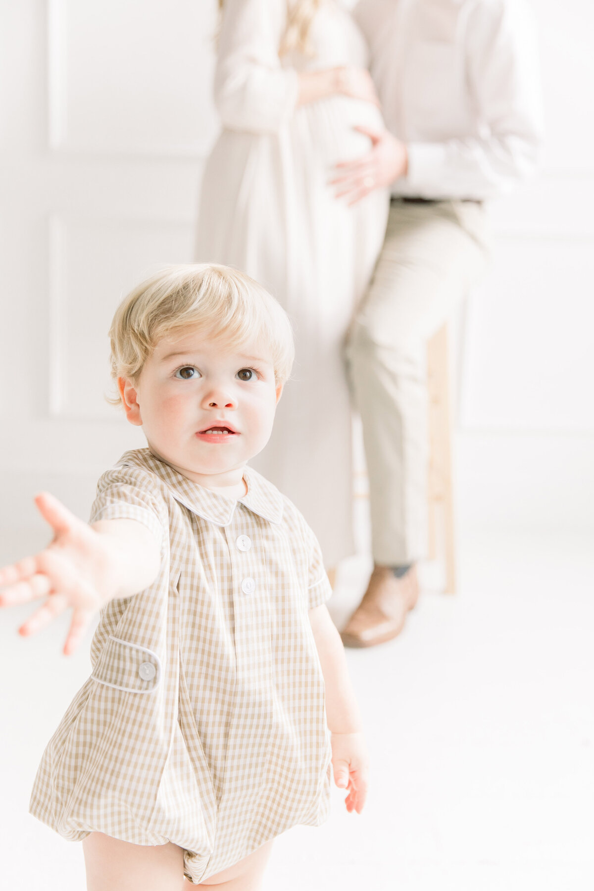 toddler boy reaching for camera during studio maternity session