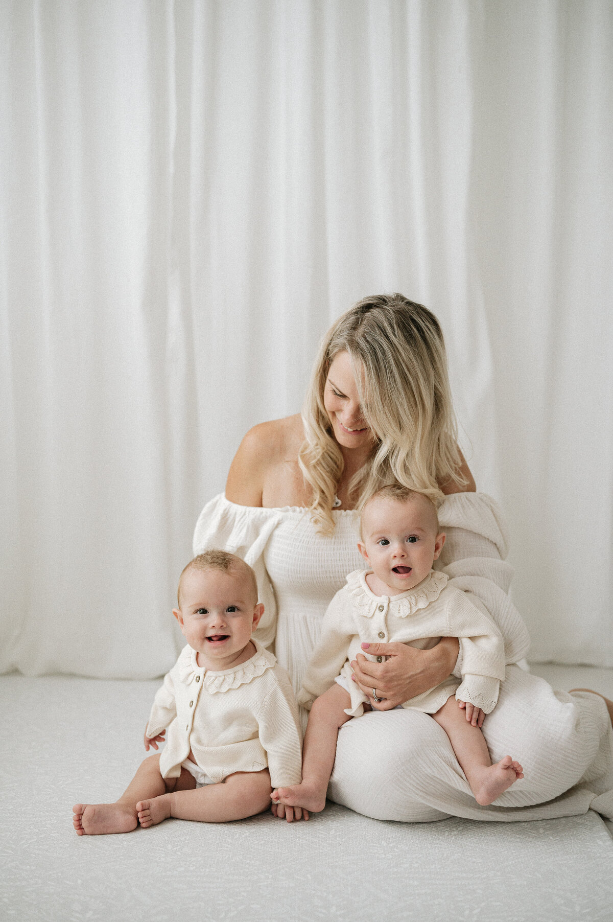 Mother holds her babies during a baby photoshoot