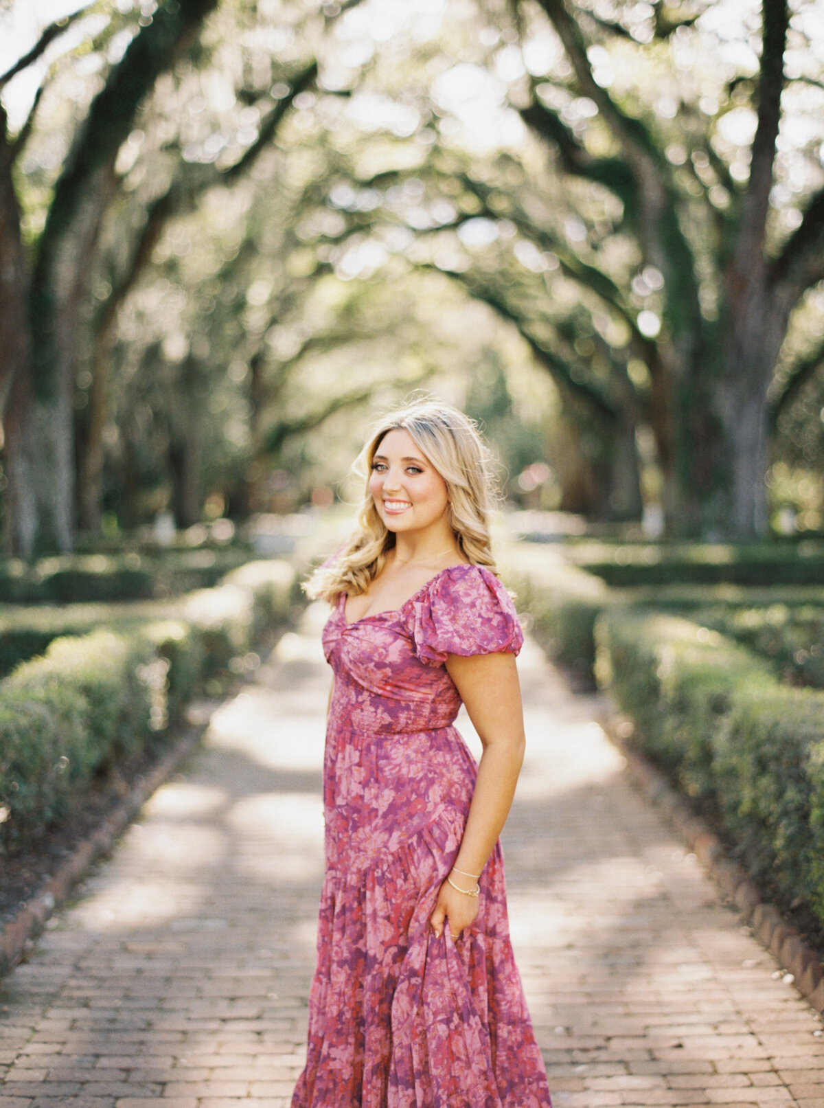 A timeless senior portrait captured among the floral splendor of Rosedown Plantation, showcasing elegance and charm on film by Morgan Alysse, Louisiana film photographer.