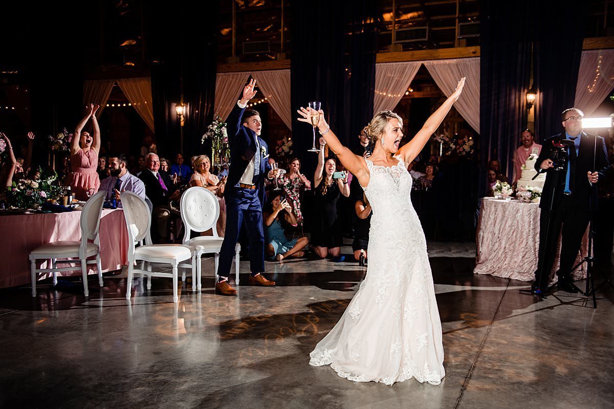 Bride and groom with hands up excited that band is beginning to play