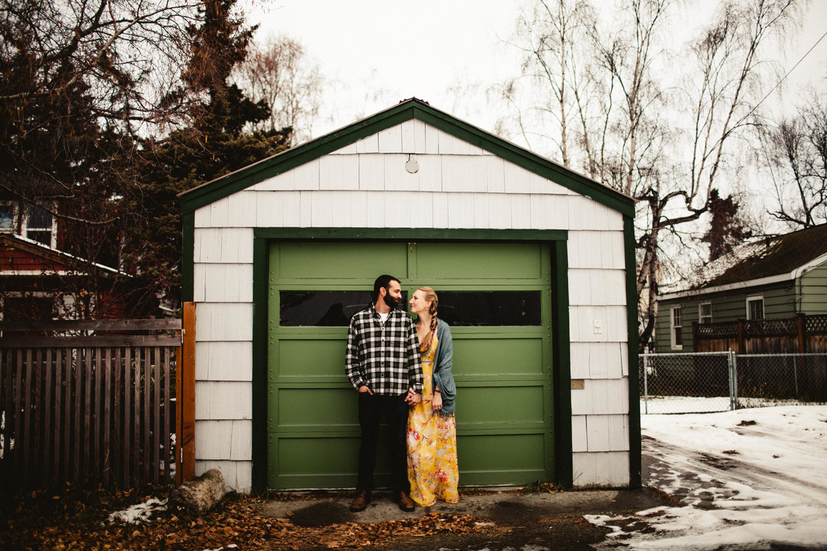 wide shot of couple in front of green garage