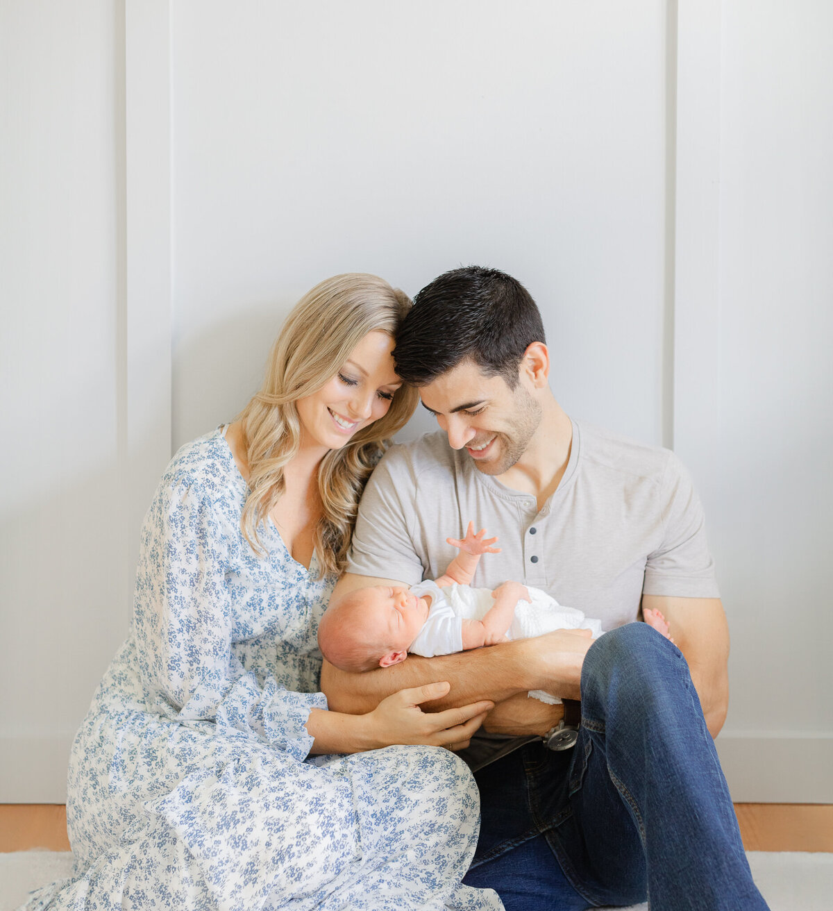 photo of new mom and dad holding newborn in nursery