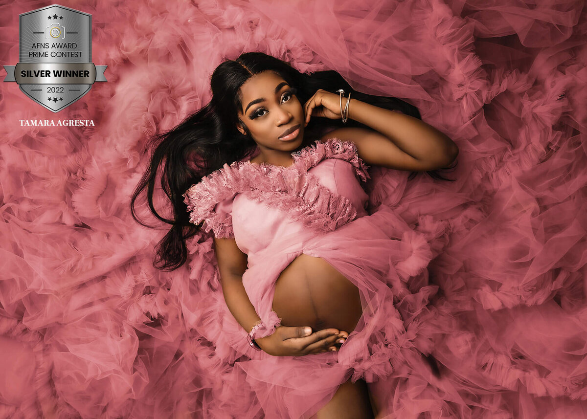 AFNS Award Winning Fine Art maternity image of a beautiful woman in a pink gown in studio.