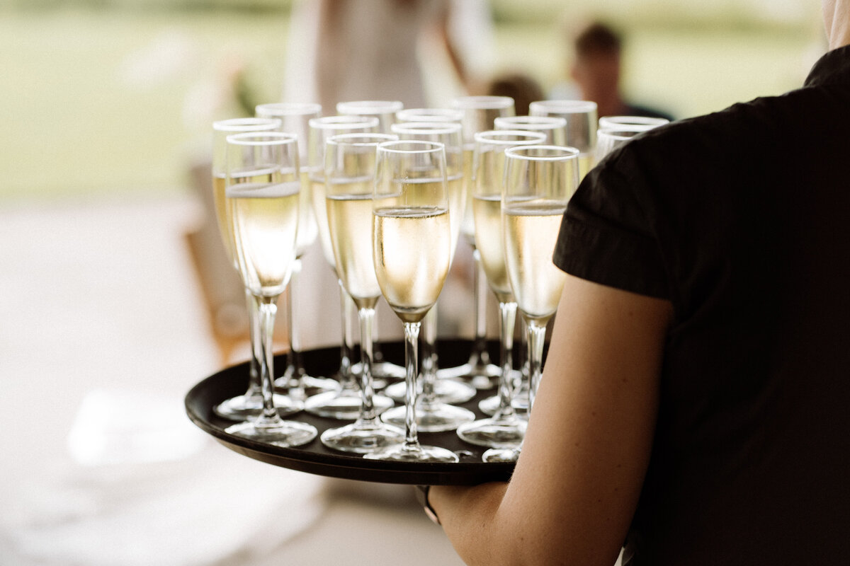 Sfeervolle bruiloft bij Nigtevecht Freeland Farm, met een persoonlijk aangekleed decor en het bruidspaar dat geniet van een lange borrel in een gezellige, intieme sfeer. Champagne glazen. 