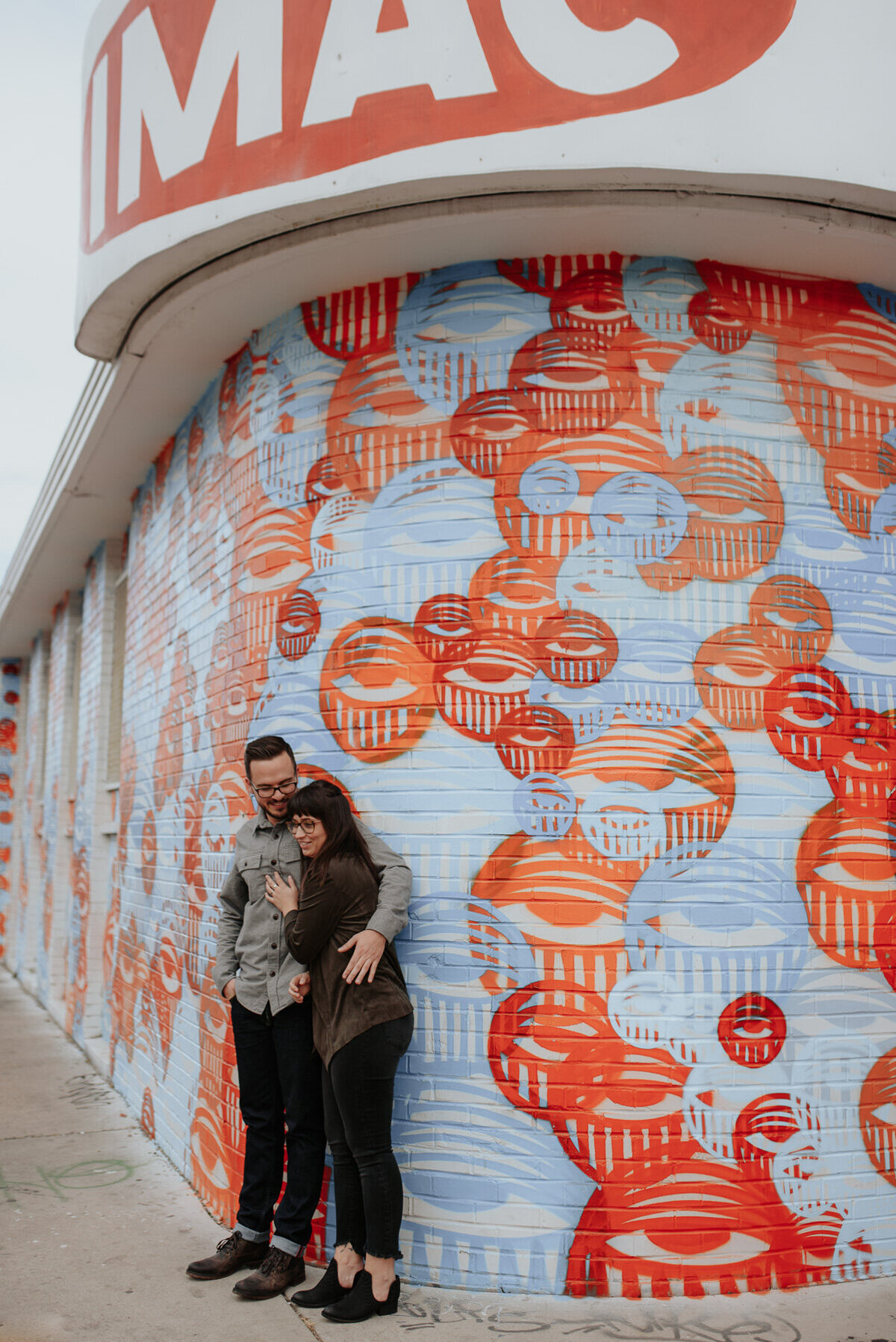 Urban picture of couple in front of art mural in downtown Denver
