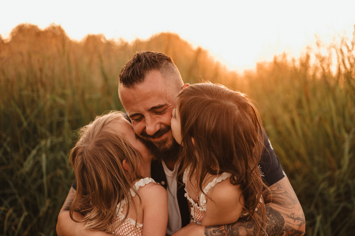 Father hugging his two daughters during a lifestyle family session in Pennsylvania