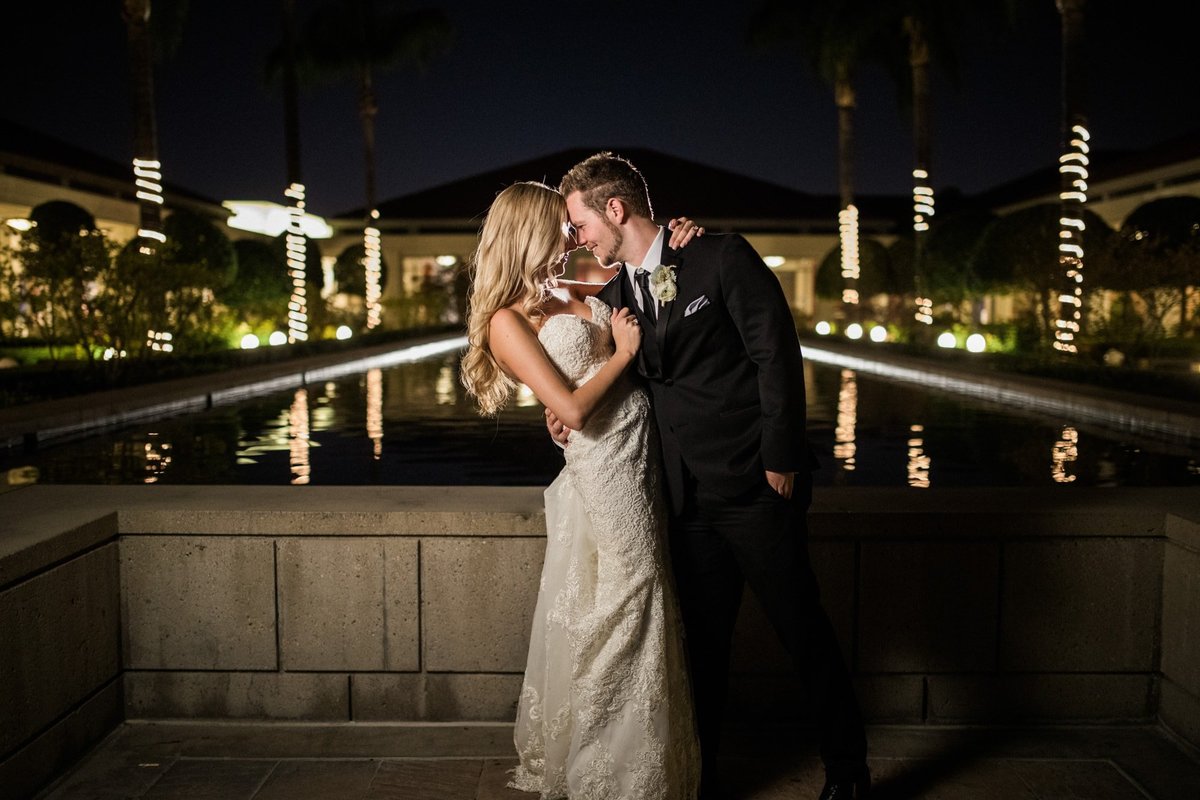 Tender moment for Bride and Groom during a night shot next to the Nixon Library Reflection Pool