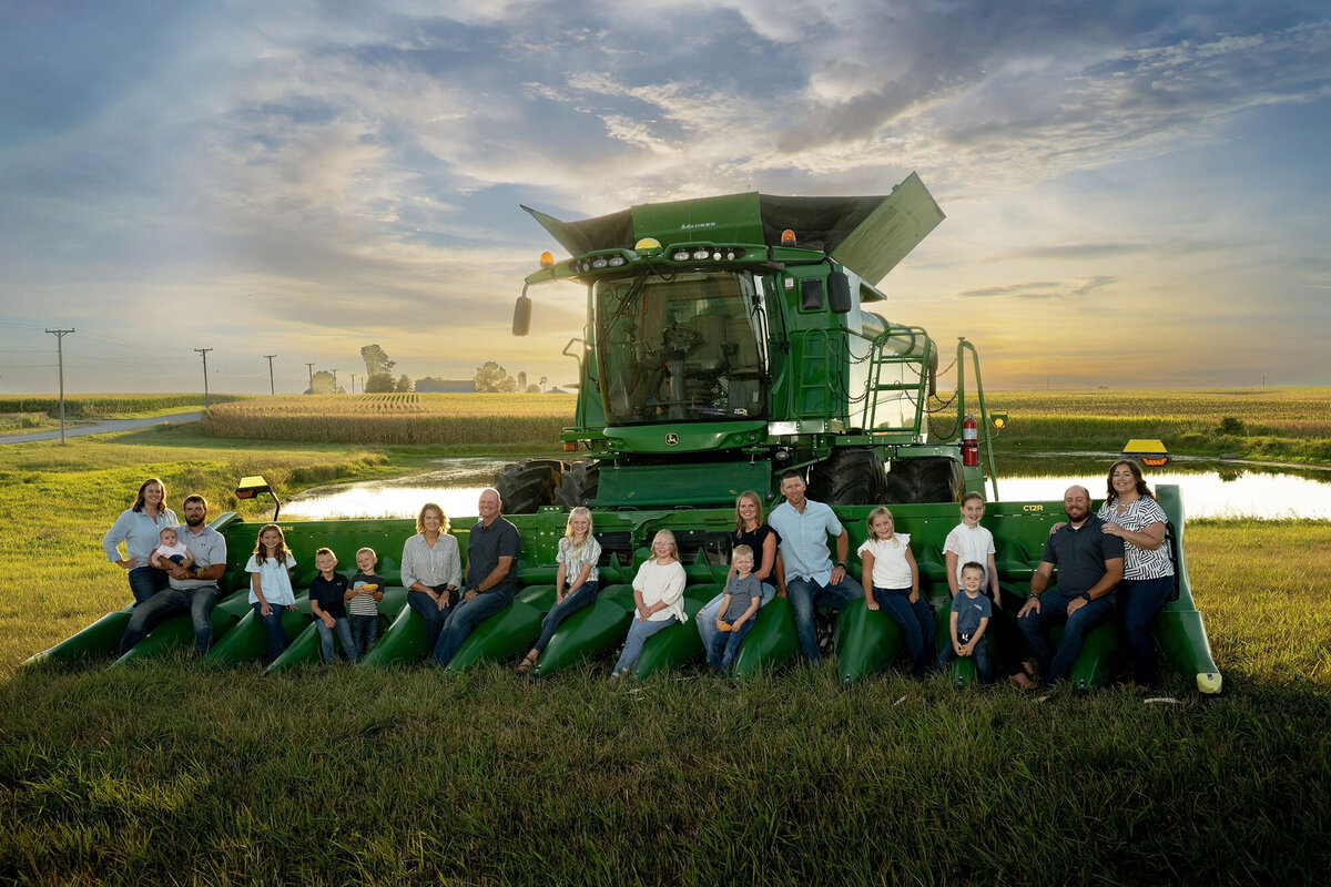 Everyone in the family sits on the front of a combine for their Pella Family Photos