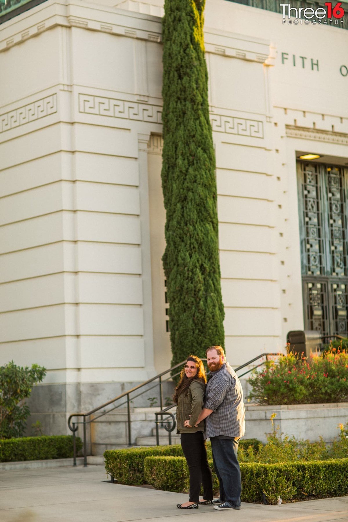 Groom to be holds his Bride from behind in front of the Griffith Observatory