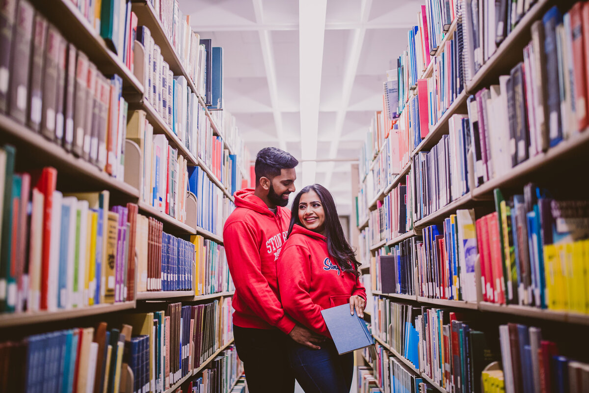 An engaged couple at their alma mater stony brook university share a moment inside the library