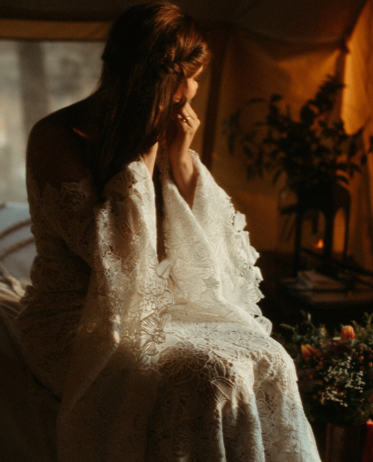 Bride in boho wedding dress with big sleeves getting ready and putting earrings in inside tent before elopement