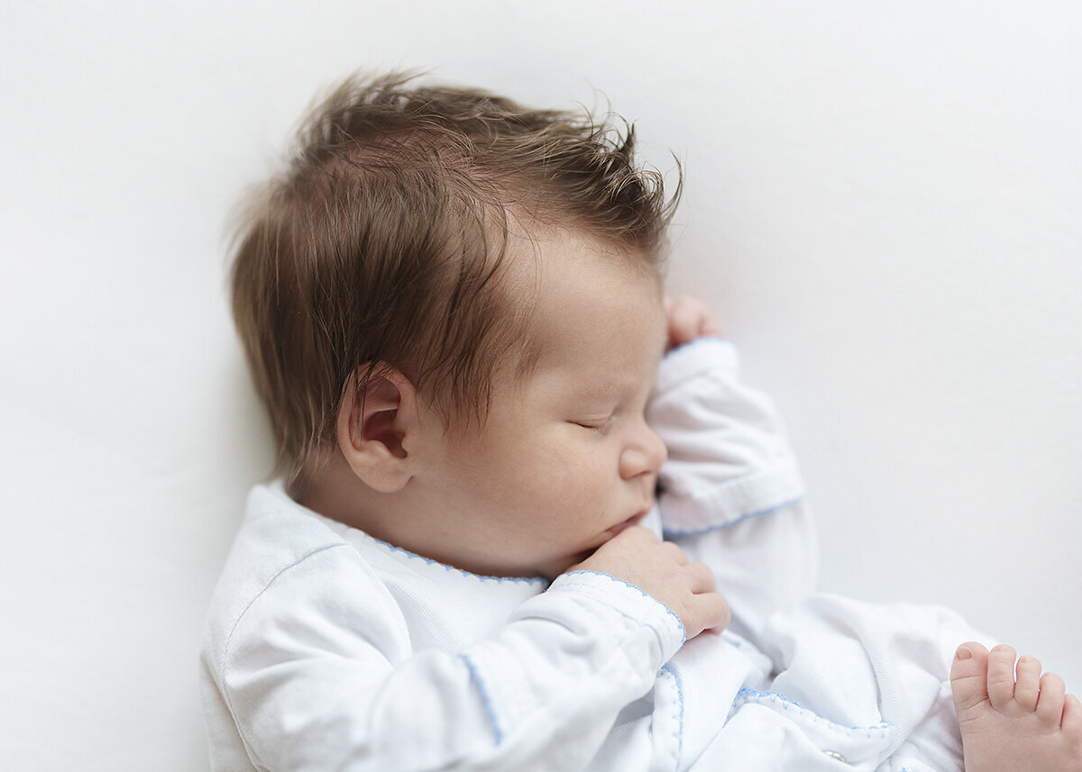 baby boy photographed in home with lots of hair oon a white background