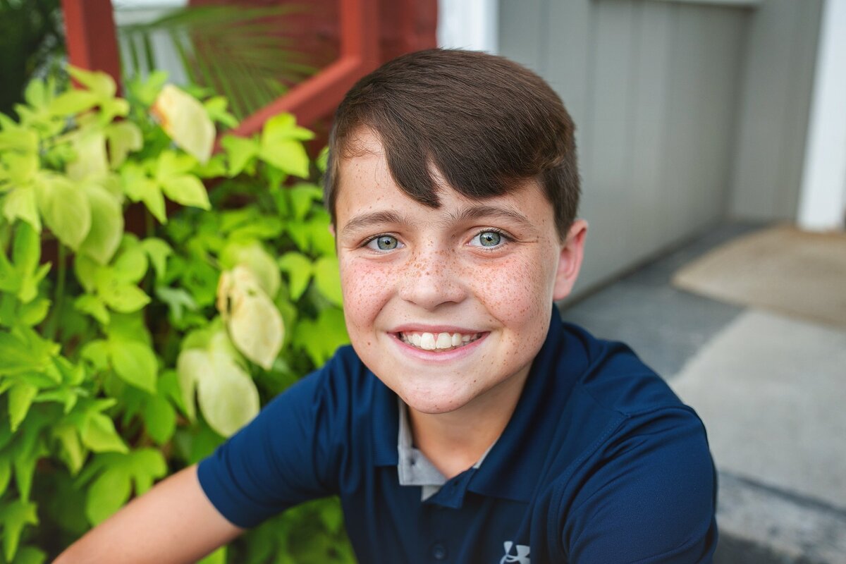 freckle-faced-boy-smiling-during-a-close-up-portrait-session-with-natural-light-in-zionsville-indiana