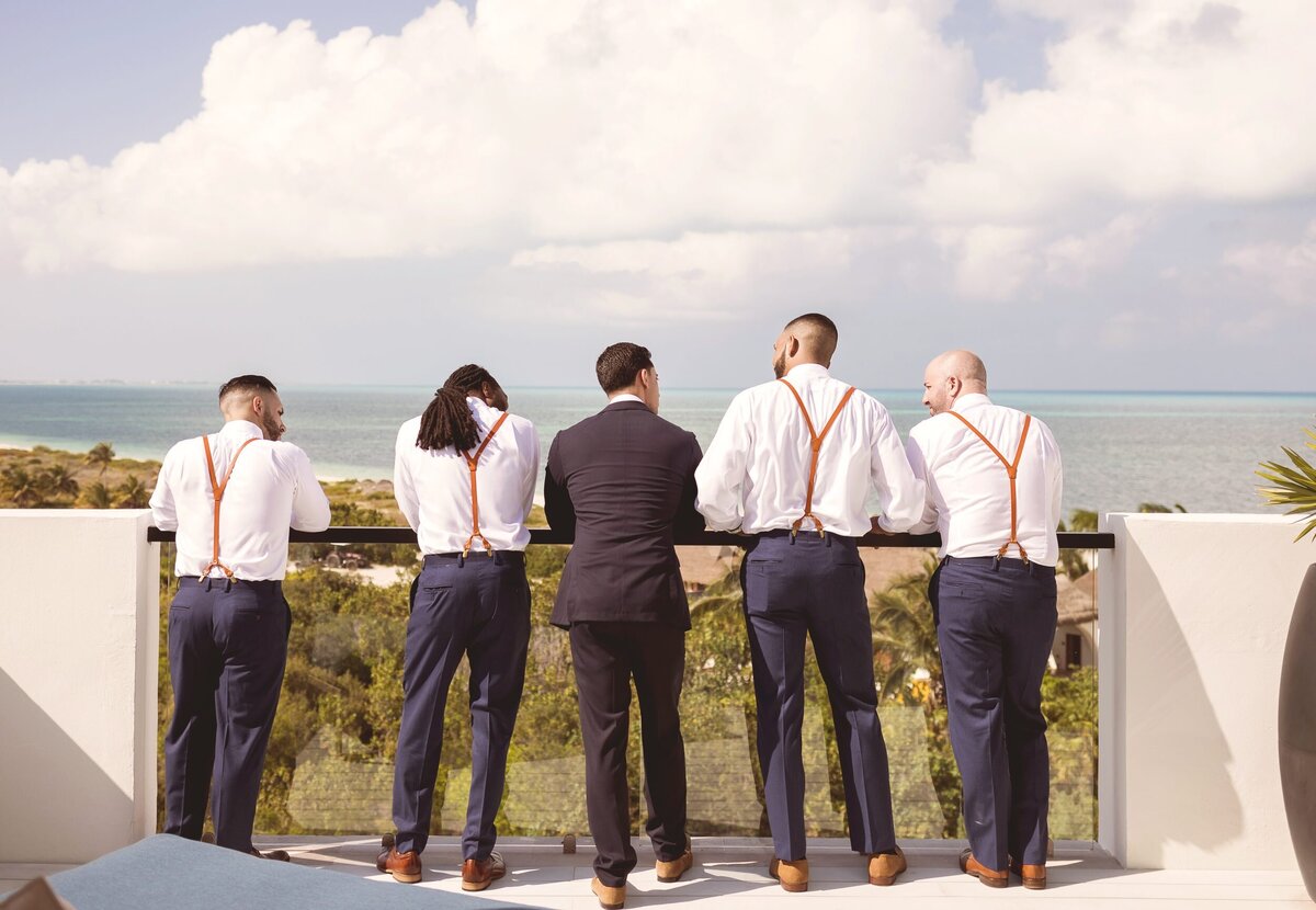 Groom and Groomsmen looking out over the ocean before wedding in Cancun