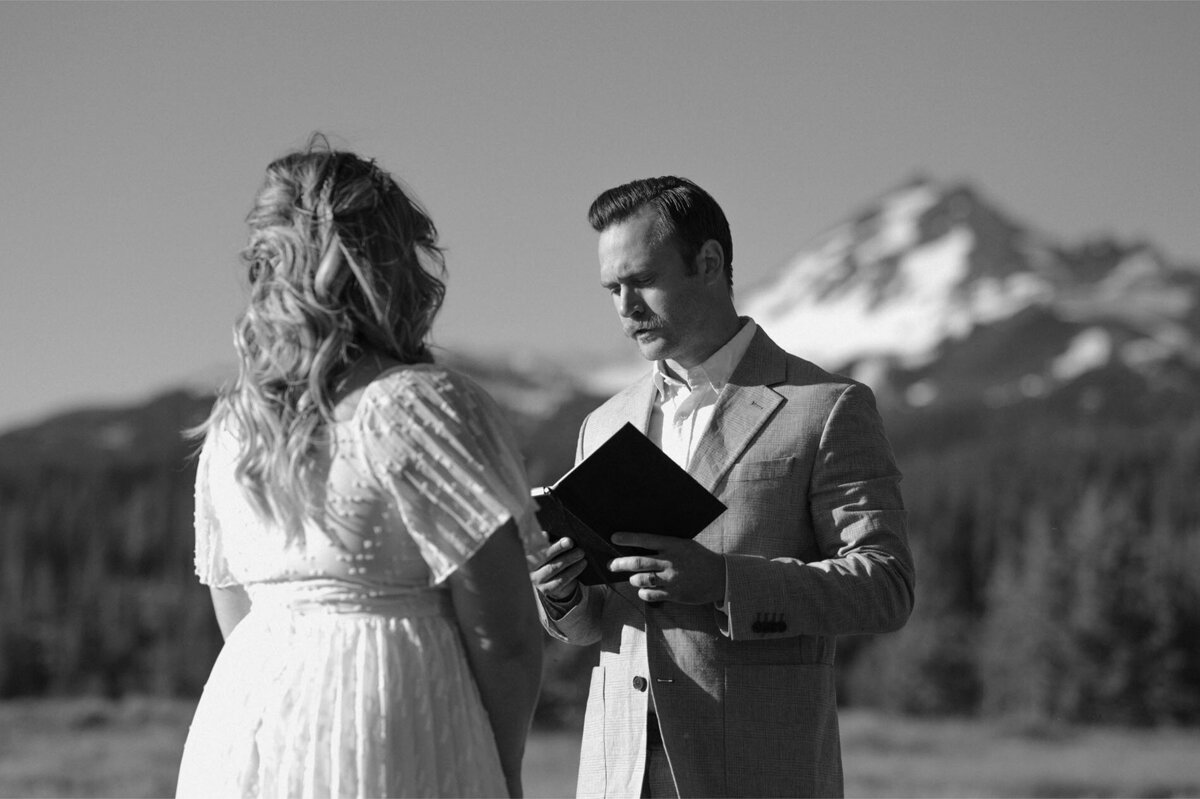 bride and groom exchange vows with one another during outdoor elopement at Mt. Bachelor