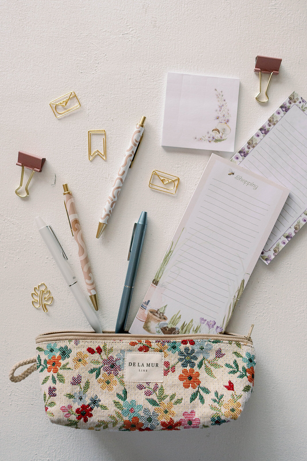 Flatlay of planner stationery items, notebooks, pens, clips, and a floral pouch during a branding session for a planner company in Indiana.