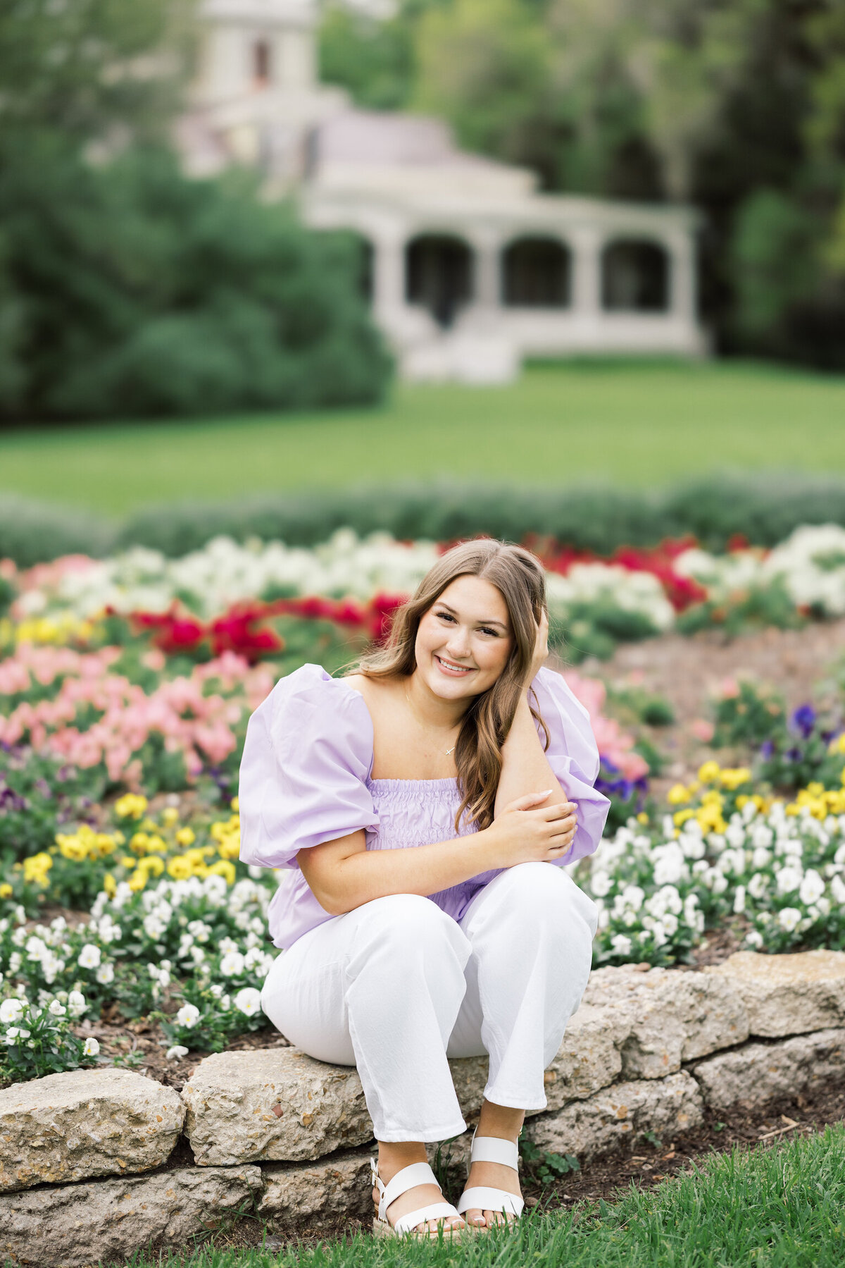 A colorful senior portrait featuring vibrant blooms at Rip Van Winkle Gardens, capturing joy and beauty on film by Morgan Alysse, Louisiana film photographer.