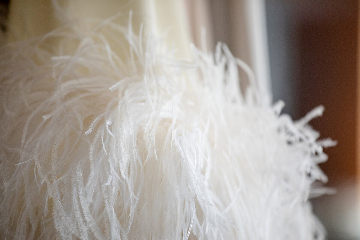 Bride in couture feather wedding gown — luxury fashion-forward wedding moment in NJ