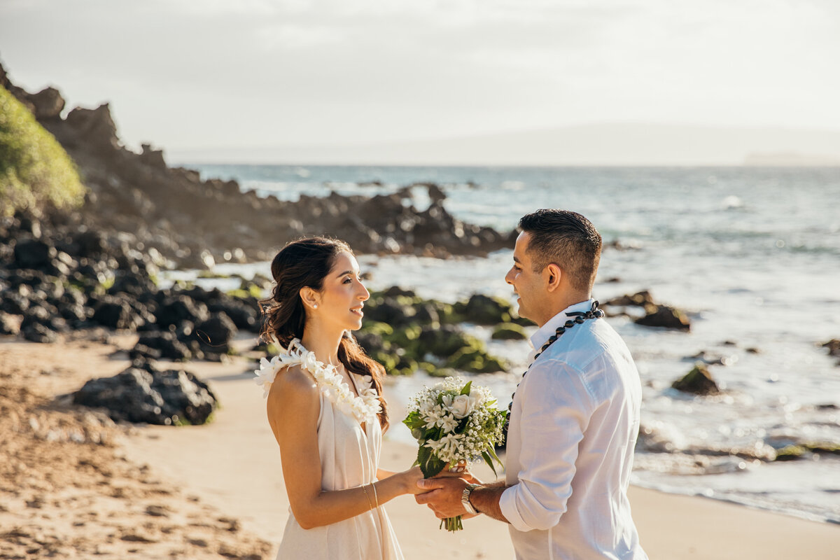 Maui Wedding Photographer captures bride and groom holding hands during maui beach wedding