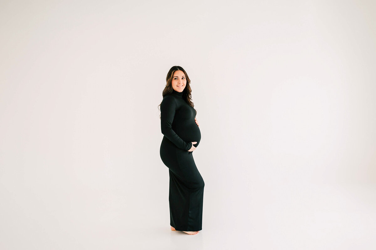 maternity photo in Springfield MO of mom holding baby bump in black dress