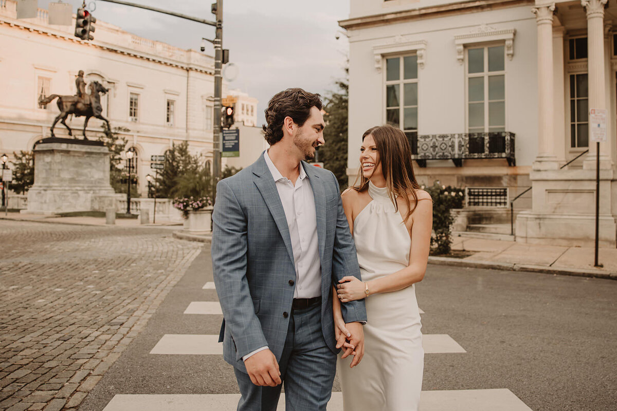 A couple holding hands and walking across a crosswalk 