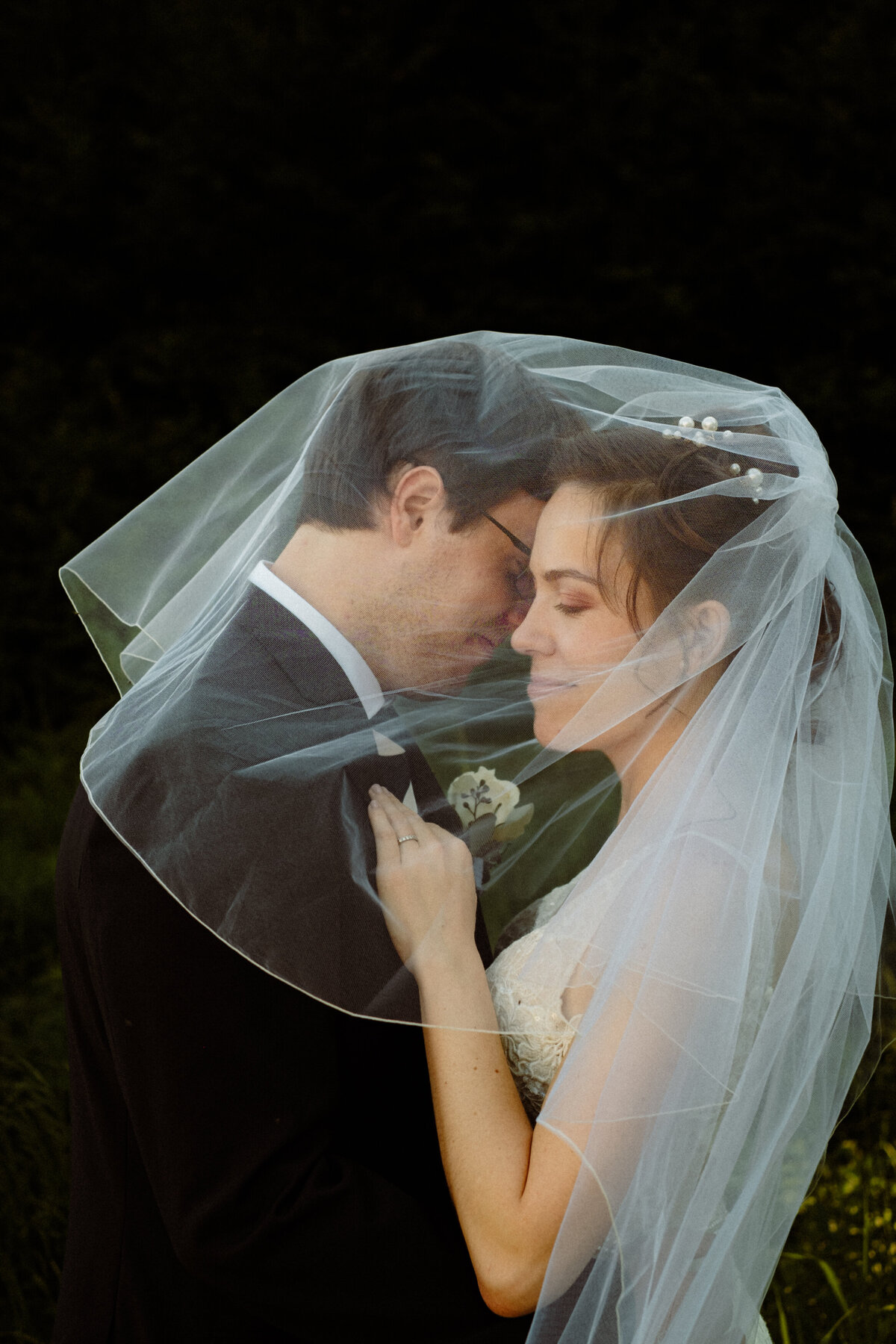 bride and groom enjoying a quiet moment under a veil