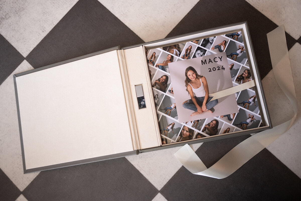 A fine art photo album lays open to high school senior photos