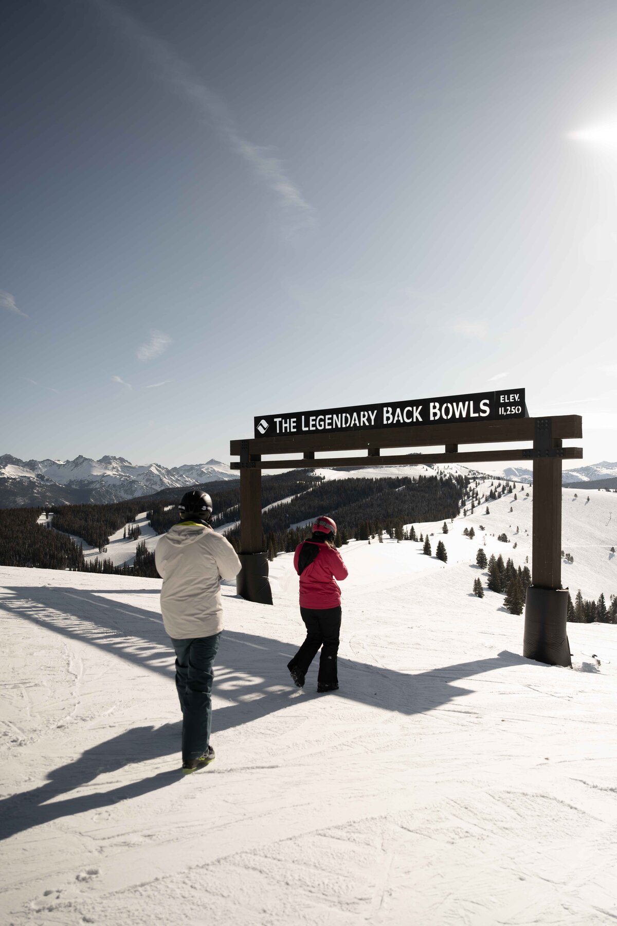 Couple standing beneath the ‘Legendary Back Bowls’ sign at Vail Ski Resort, overlooking breathtaking snow-covered peaks and vast alpine terrain. This adventurous winter elopement captures the essence of love and exploration in the heart of the Colorado Rockies. Perfect for couples seeking an intimate, scenic, and unforgettable mountain wedding experience. 