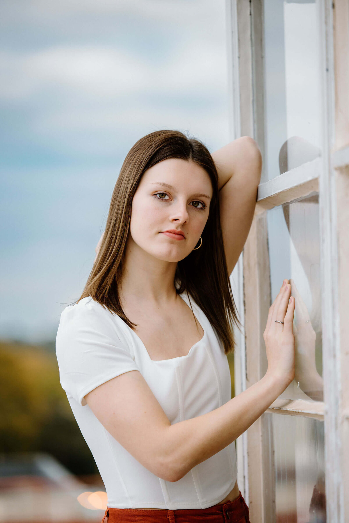 photograph of 2023 Hallsville graduate leaning on window in the city