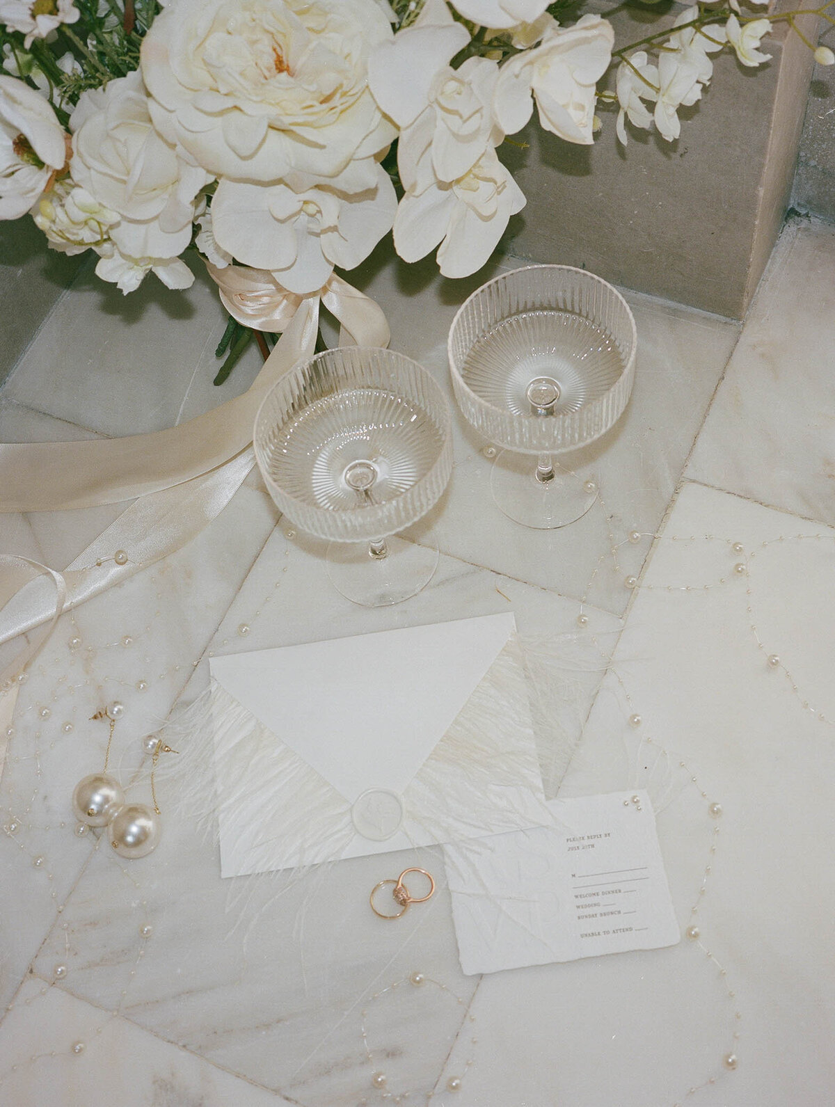 Close up of wedding details including cocktail glasses and pearls