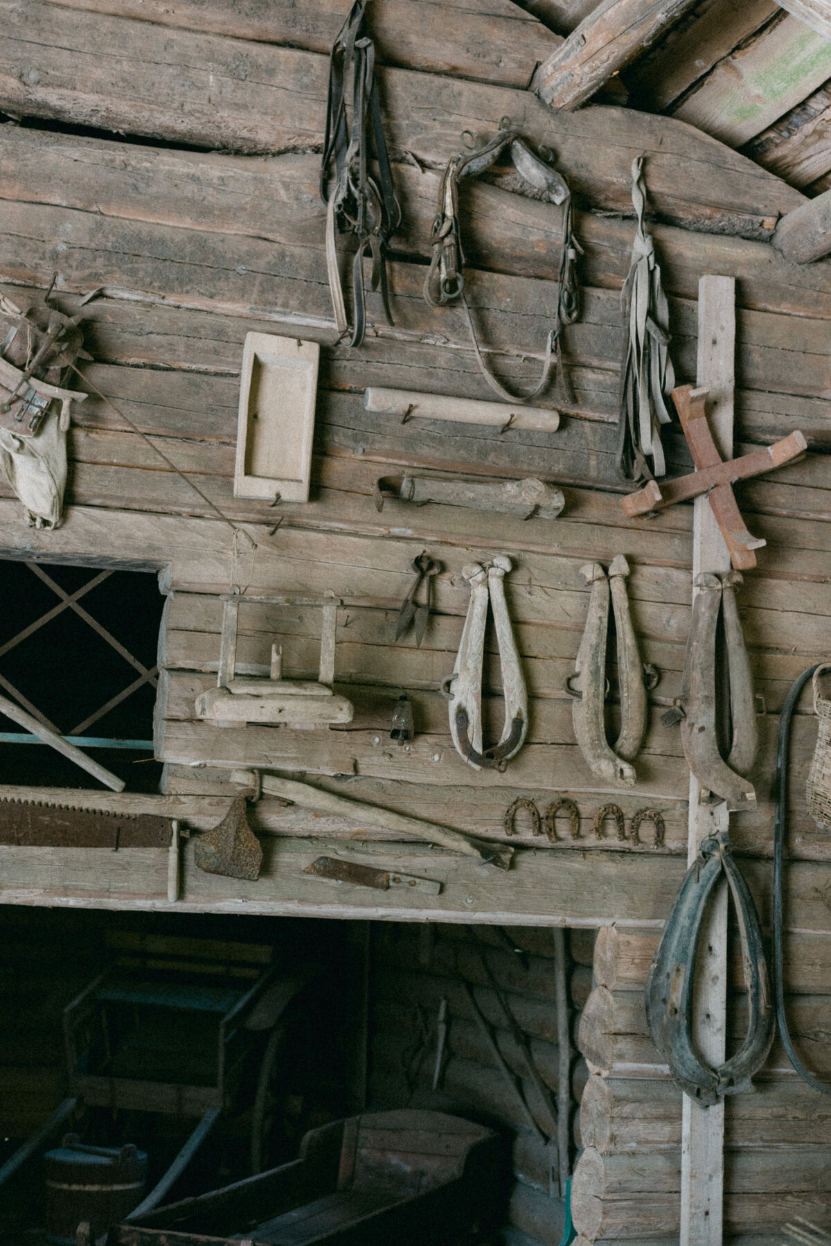 Old horse harnesses hanging on the wall. An image by wedding photographer Hannika Gabrielsson.