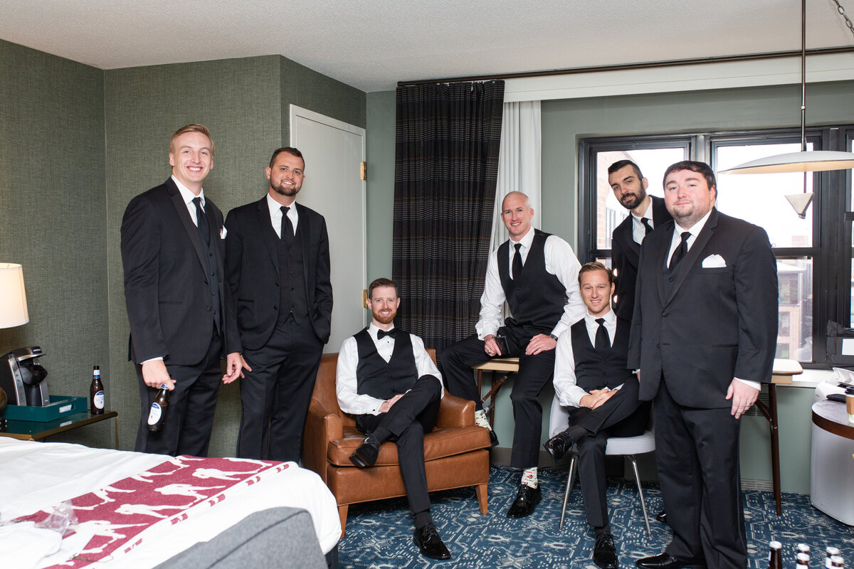 Grooms party pose for photo in getting ready suite on groom's wedding day