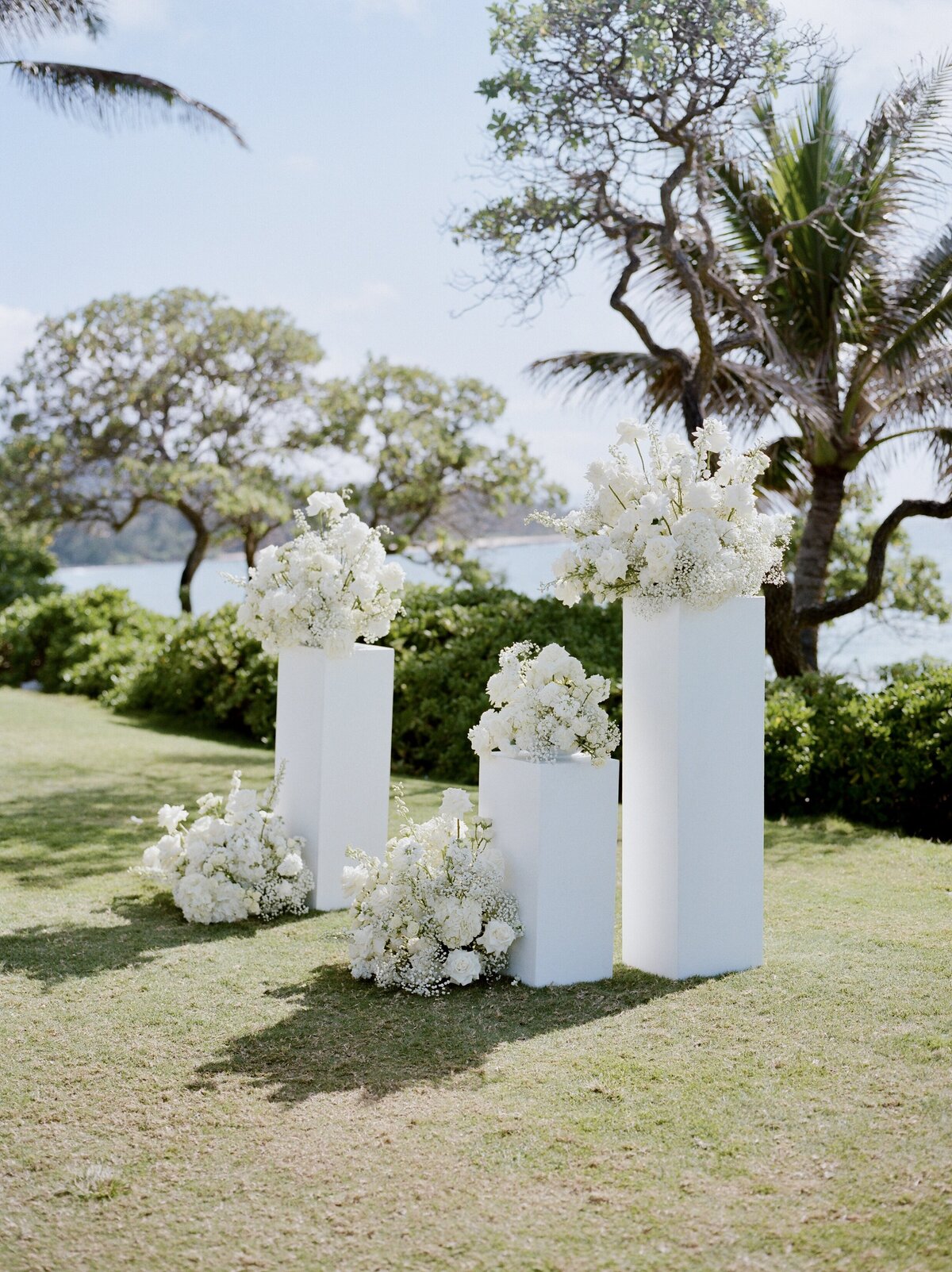 Elegant floral ceremony setup overlooking the ocean at Turtle Bay on Oʻahu’s North Shore, captured on nostalgic film by Kate Winters Photography