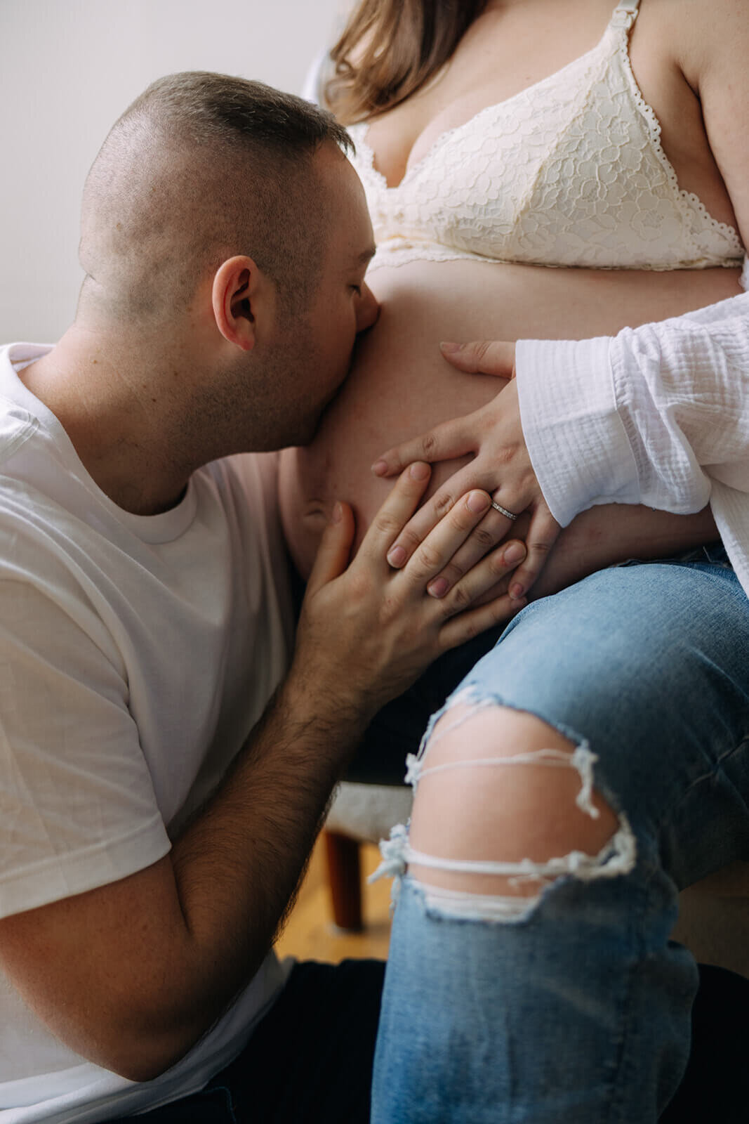 Man kissing bare baby bump at  Finger Lakes Maternity session