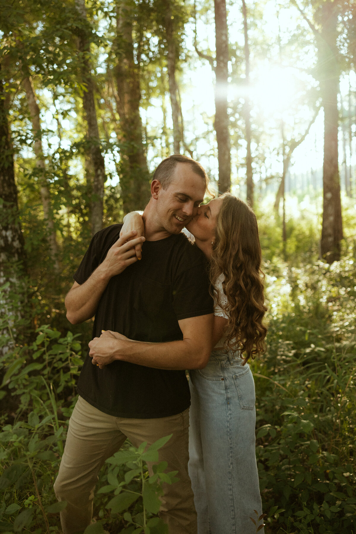 Couple posing for portraits in a forest.