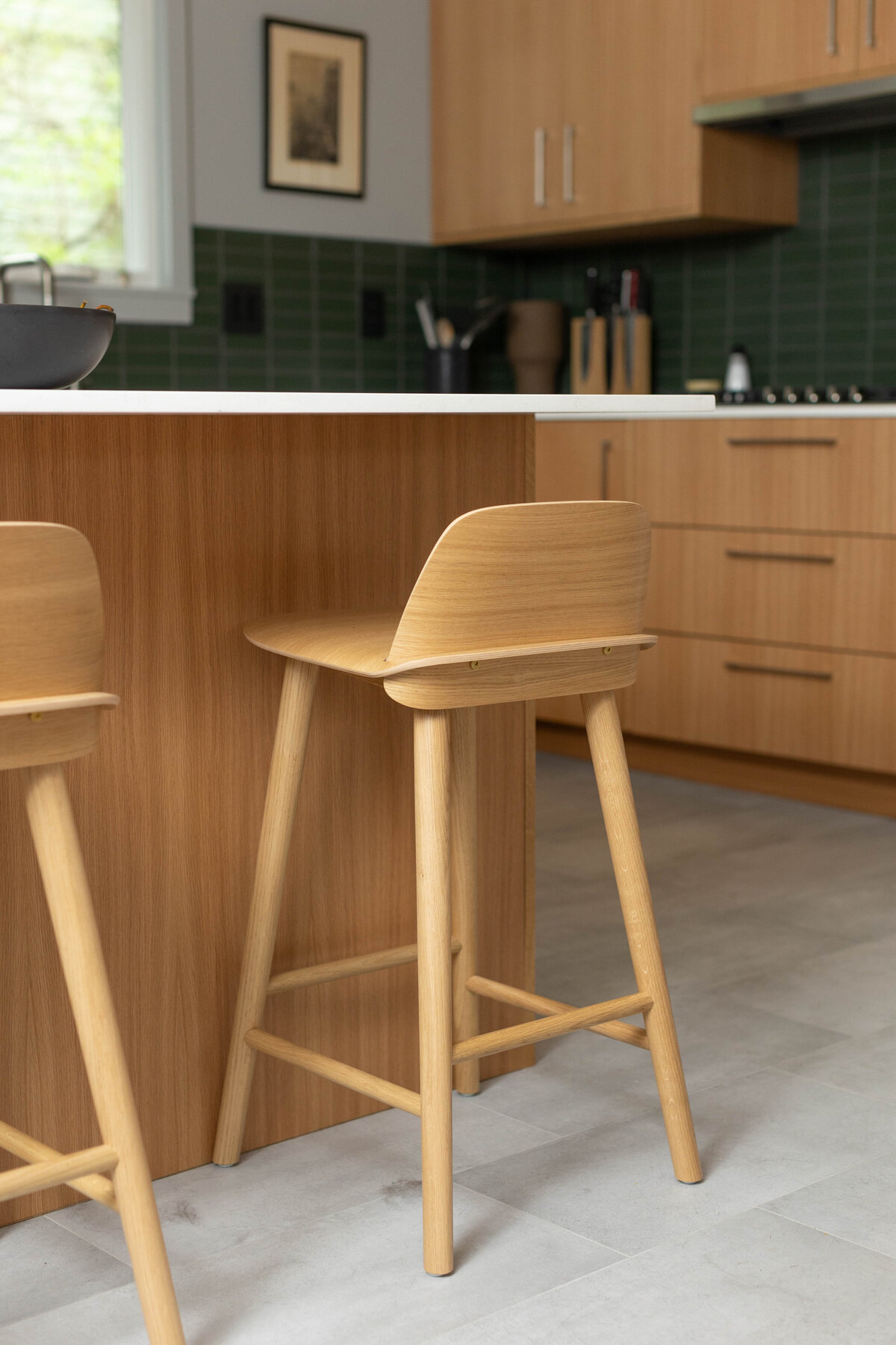 Light wood kitchen stool pushed against a wood and marble counter