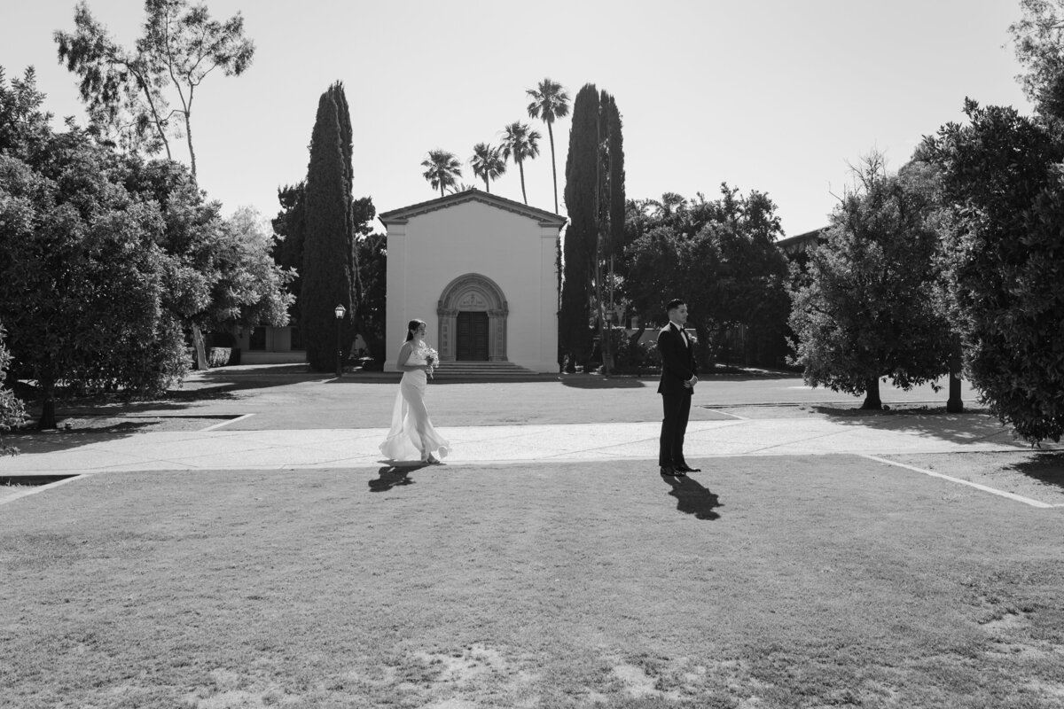 Katie walking up to Sebastian for their first look at their elopement in Claremont California, in black and white.