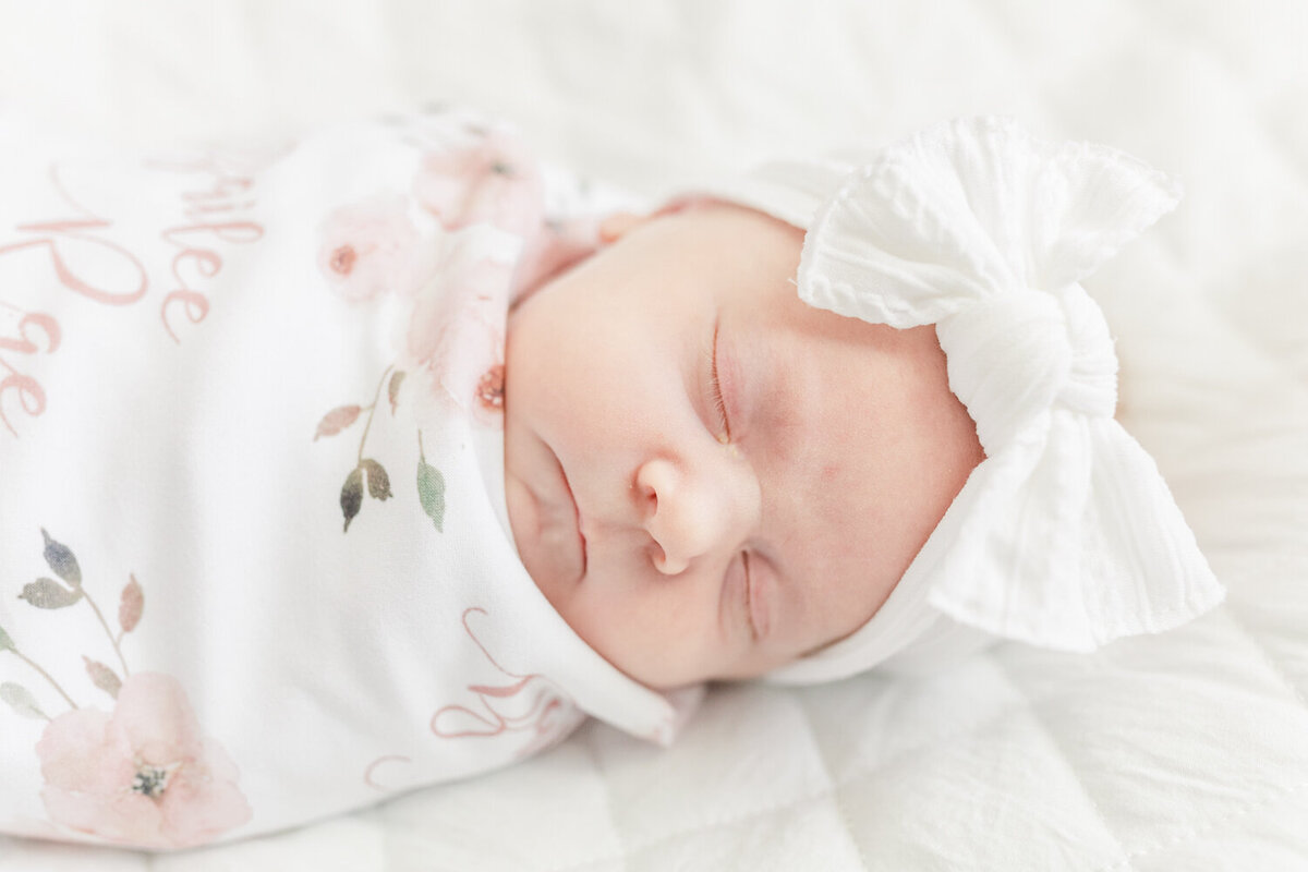 newborn baby girl sleeping peacefully while swaddled