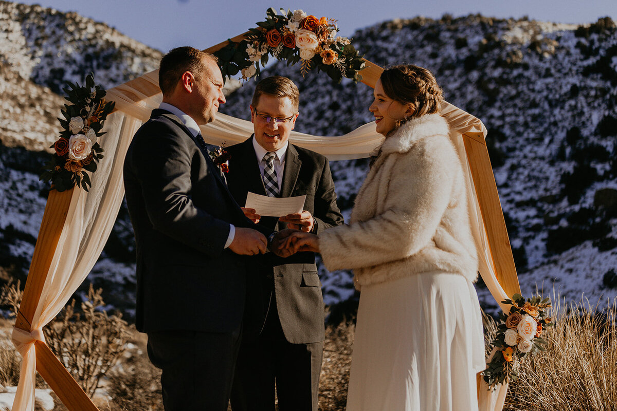 bride and groom having their ceremony on the snowy Sandia Mountains in Albuquerque