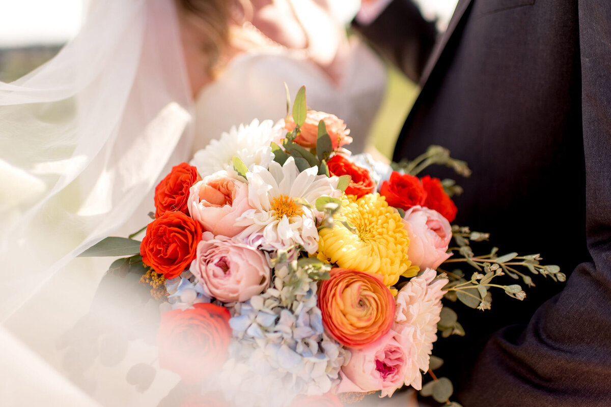 Gorgeous, colourful summer bouquet of yellow, pink, and red peonies and roses, captured by Janelle Dudzic Photography, colourful and candid wedding photographer in Edmonton, Alberta. Featured on the Bronte Bride Vendor Guide.