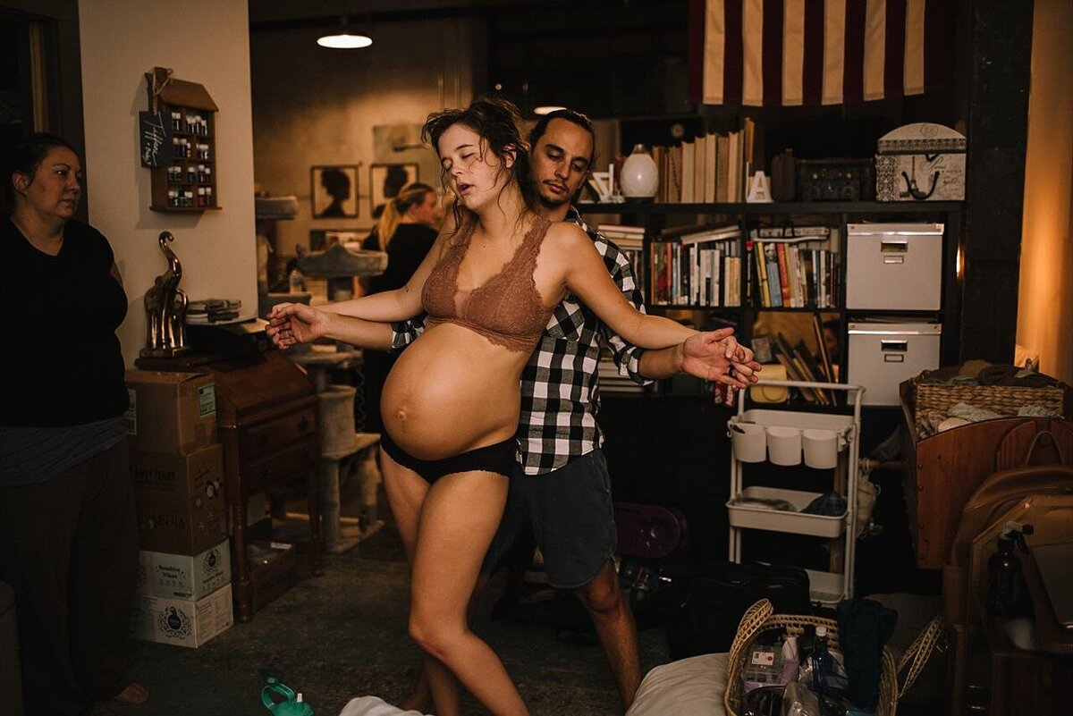An intimate moment between parents as they share a kiss or a knowing glance during the birth of their child, symbolizing love and unity.