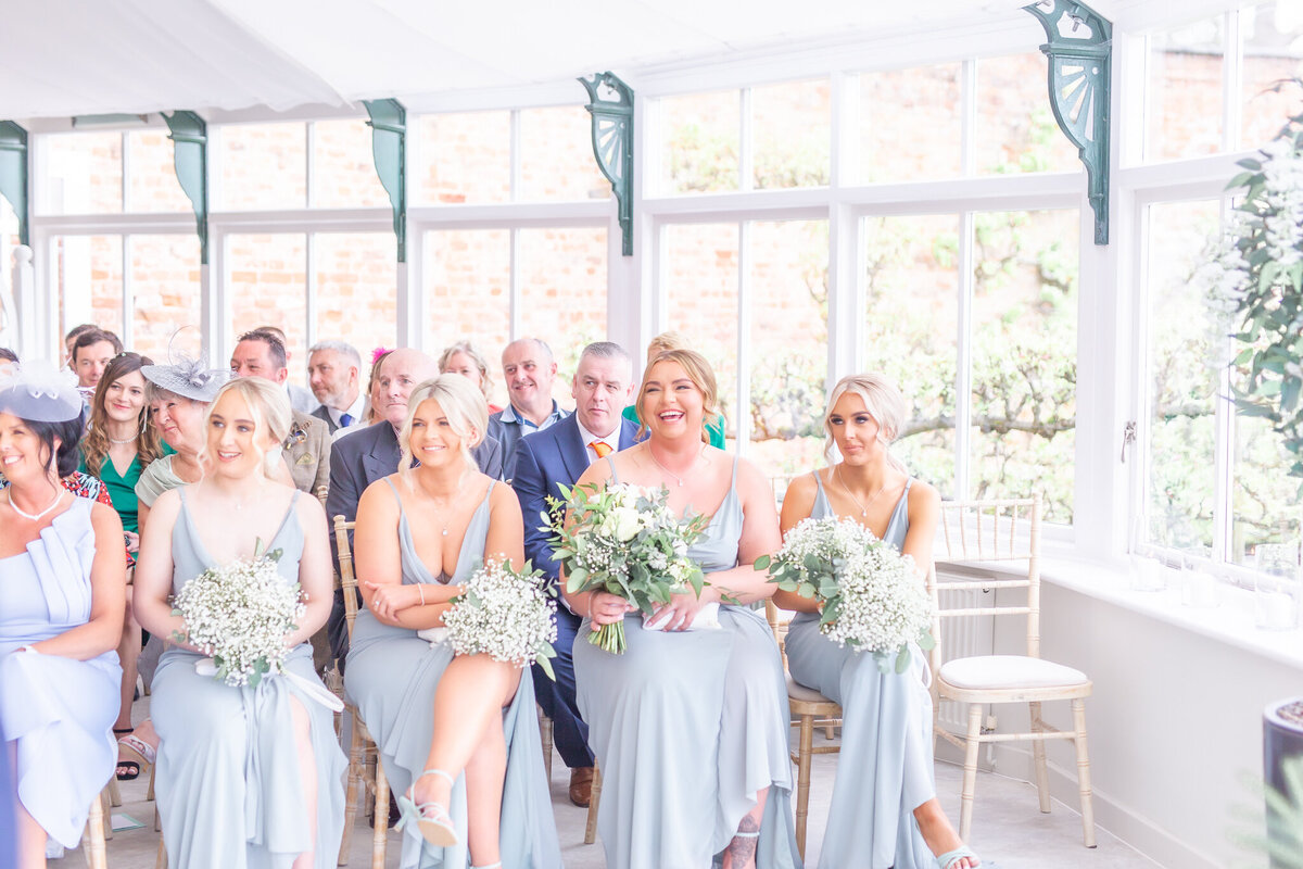 Four bridesmaids sat down during the ceremony at Combermere Abbey