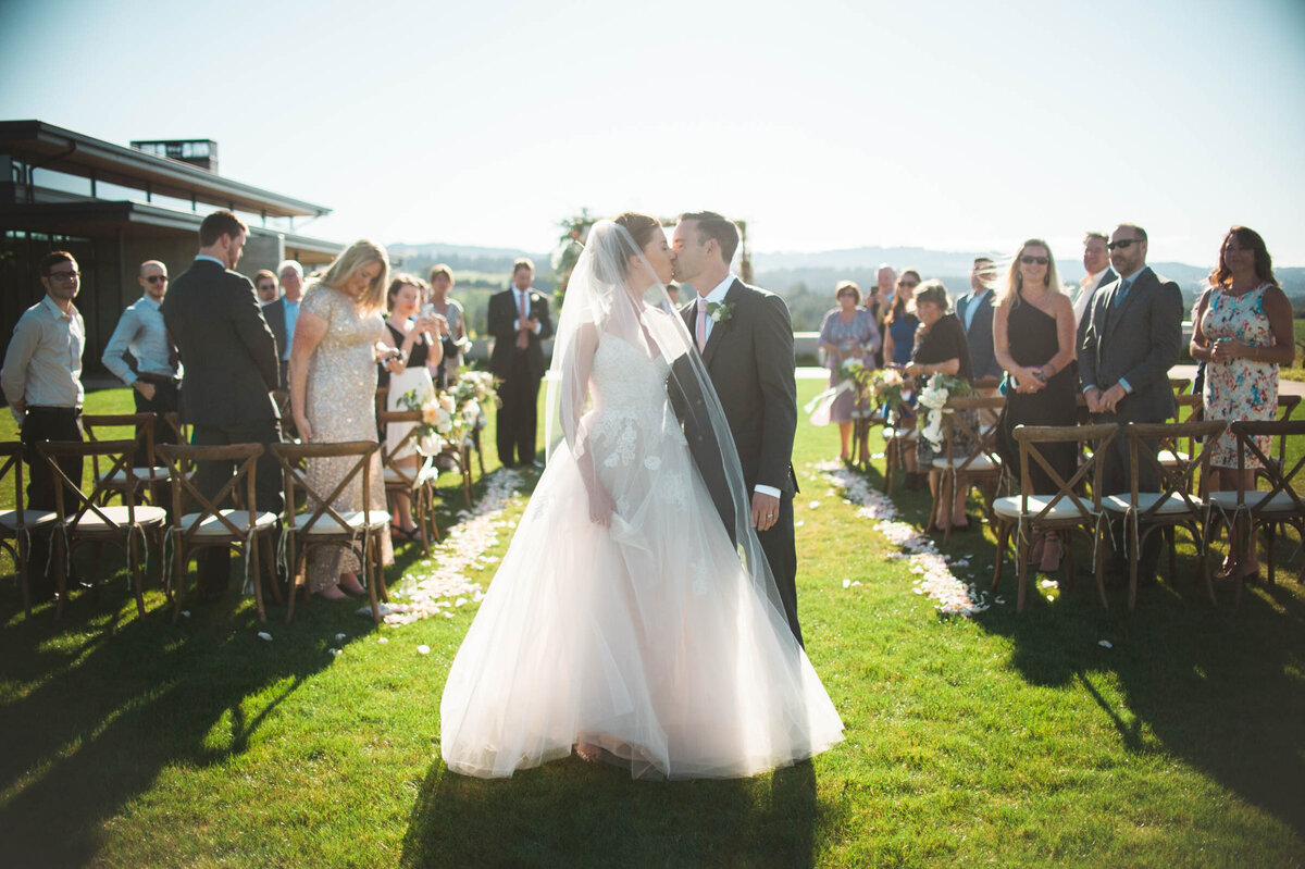 wedding couple sharing kiss after wedding ceremony at ponzi winery